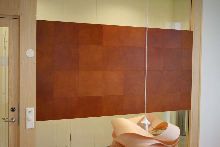 Läderplattor fästa på vägg på Einar Mattssons kontor.