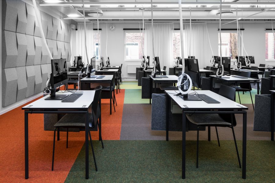 Heltäckande matta Tretford lagd i olika färgfält under skrivbord i Karolinska Skrivsal, Link Arkitektur.